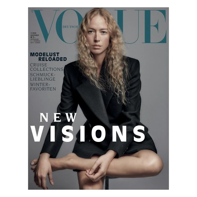 Vogue Deutsch cover featuring a woman with blonde hair in a black blazer sitting against a gray background with large magazine text.