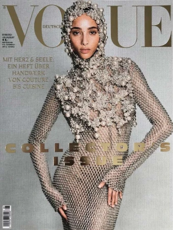 Vogue magazine cover featuring a model in a pearl-beaded headpiece and a metal mesh dress against a textured gray background.