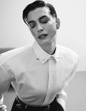 Black and white portrait of a woman wearing a white collared shirt with a pencil pinned through the collar points.