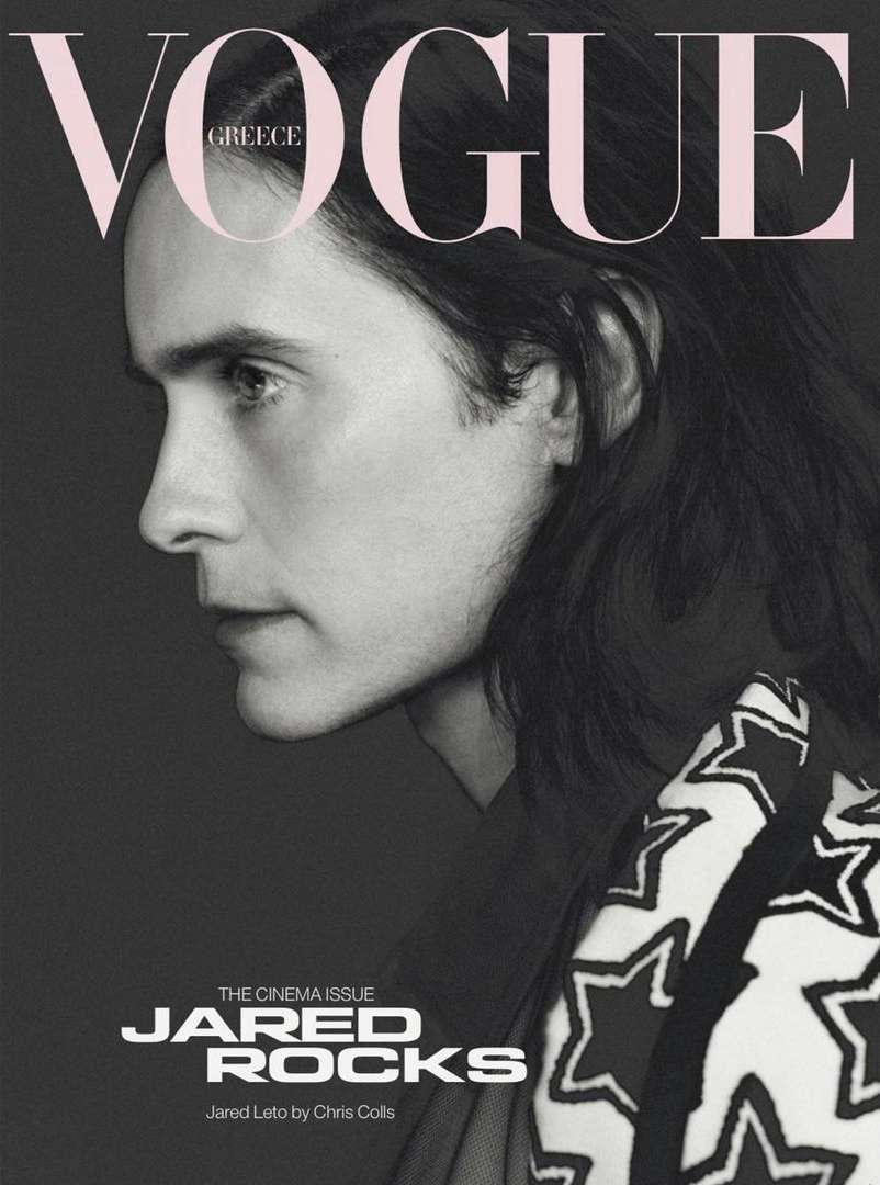 Jared Leto in a monochrome fashion portrait for Vogue Greece, featuring a star-patterned garment against a grey backdrop with bold typography.