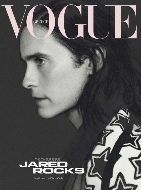Jared Leto in a monochrome fashion portrait for Vogue Greece, featuring a star-patterned garment against a grey backdrop with bold typography.