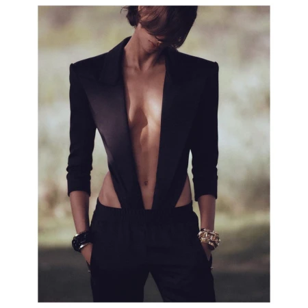 Model wearing a structured black blazer with a plunging neckline and matching trousers photographed by Chris Colls.