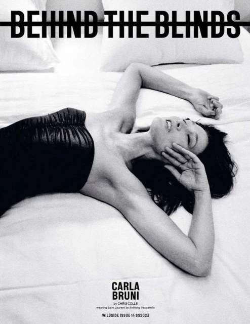 Black and white portrait of a woman lying on her back on a bed with a black top, eyes closed, and arm raised to her face.