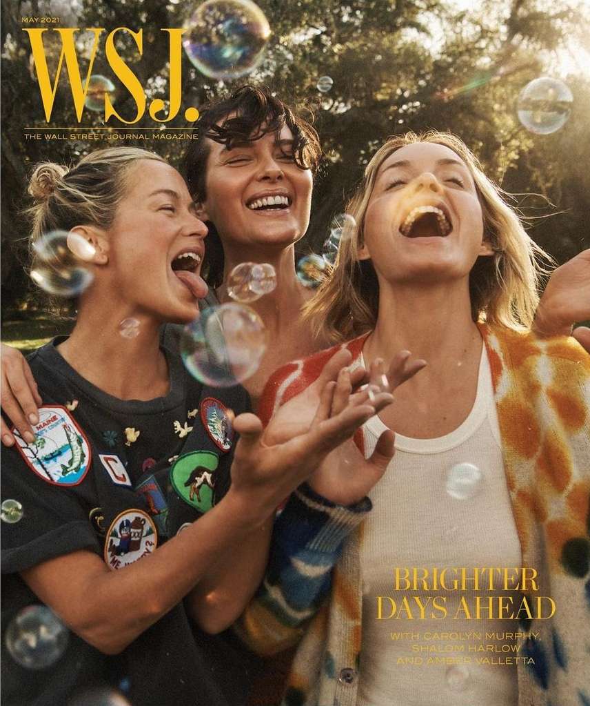 WSJ magazine cover with three women laughing in bright outdoor setting with sunlight, trees, and floating bubbles.