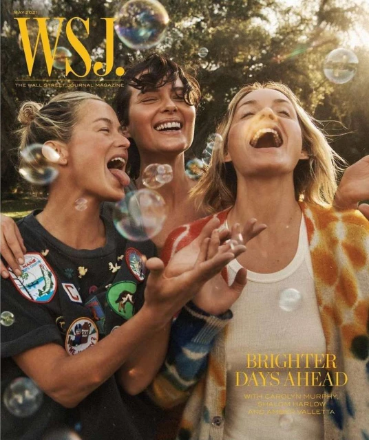 WSJ magazine cover with three women laughing in bright outdoor setting with sunlight, trees, and floating bubbles.