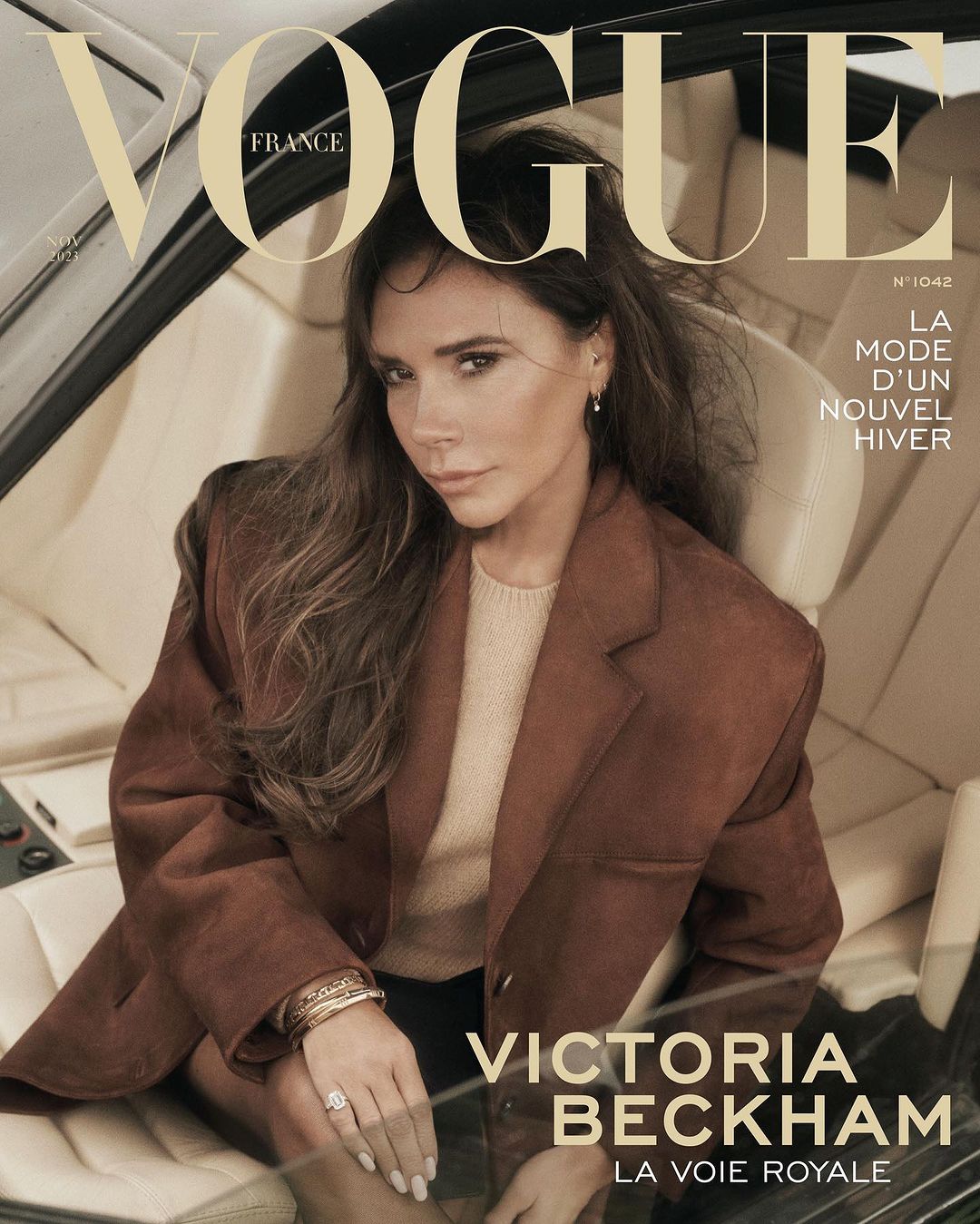 Victoria Beckham on the cover of Vogue France, wearing a brown jacket in a car interior, promoting the latest winter fashion trends.