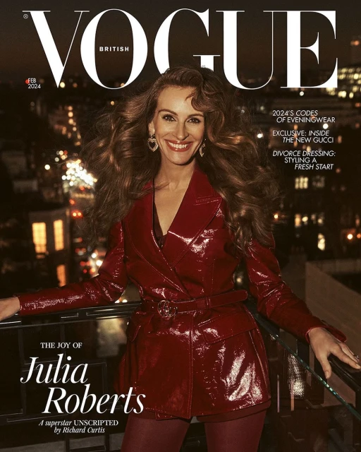 British Vogue cover featuring Julia Roberts in a red, belted jacket, set against an urban night scene with blurred city lights.