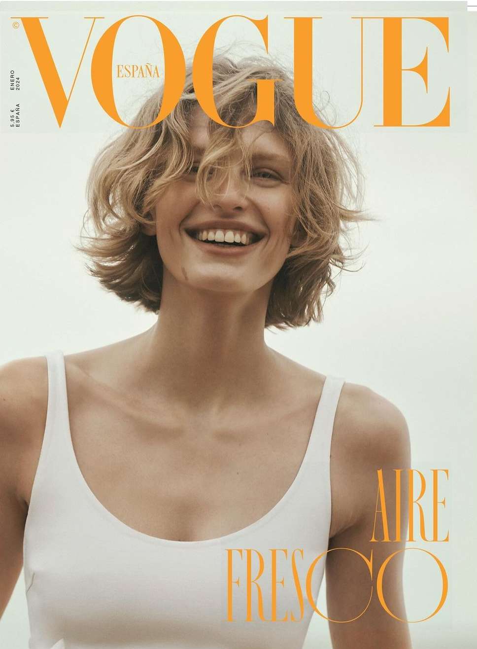 Vogue Espana cover featuring a smiling woman with short blonde hair wearing a white top, set against a bright background.