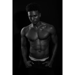 Portrait of a shirtless man wearing branded underwear in a moody monochrome studio setting by Barry Conrad