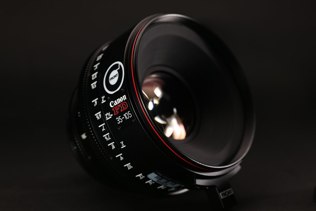 Close-up of a Canon FD 35-105mm lens against a dark backdrop, highlighting its optics, design, and professional-grade features.