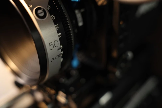 Close-up of a professional camera lens with a focus of 50mm, showcasing the intricate details of the equipment.