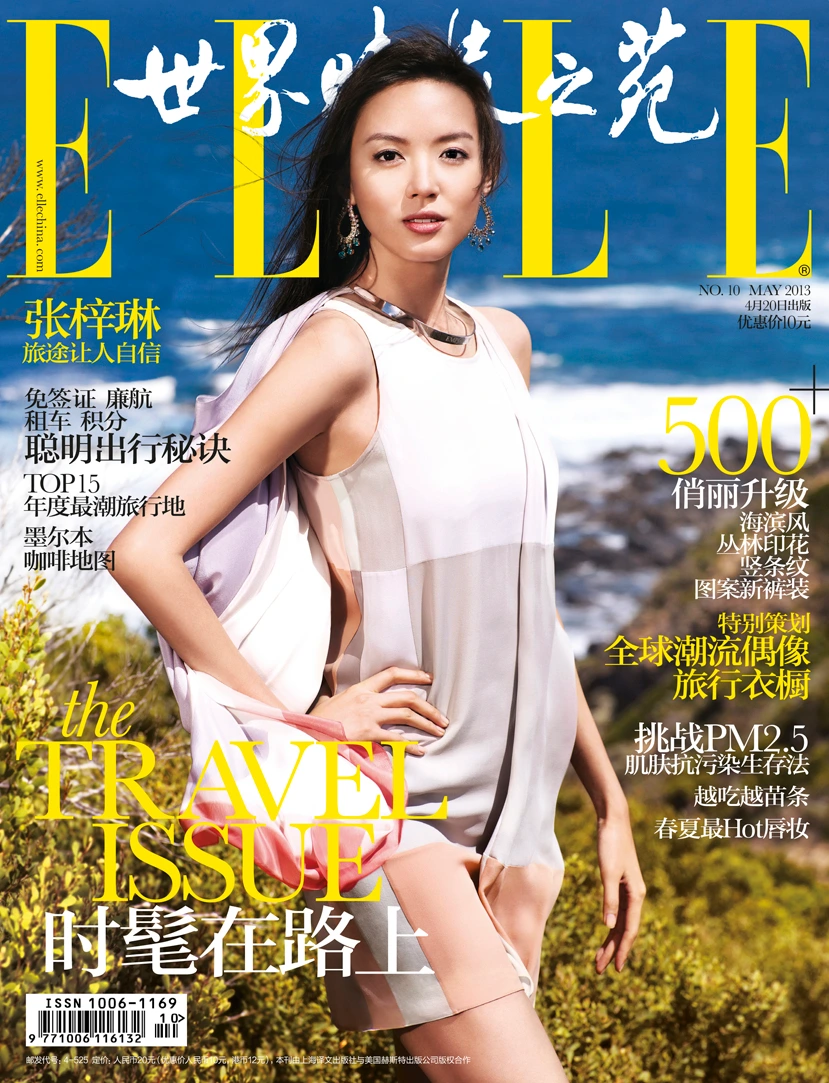 Magazine cover featuring an Asian woman in a sleeveless patterned dress posing outdoors with an ocean and rocky coastline background.