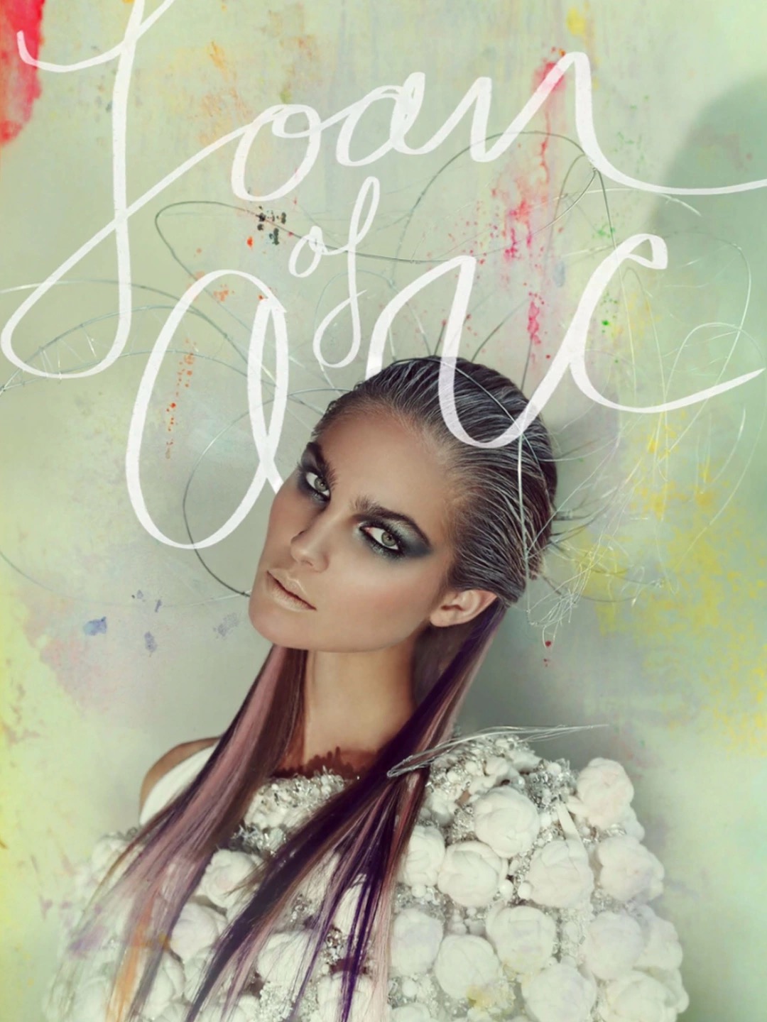 Fashion portrait of a woman with dyed hair, smokey eye makeup, and an elaborate white, bulbous-textured dress against a mottled background.