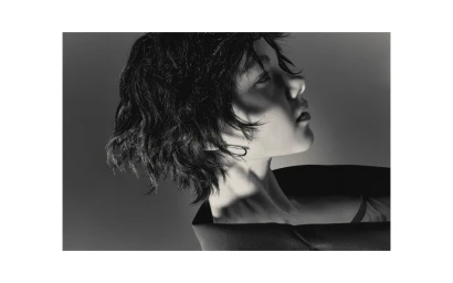 Profile portrait of a model with dark wavy hair and an earring against a gradient background by Stephanie Cammarano in Melbourne