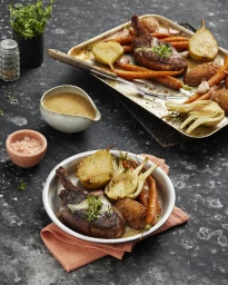 Roasted pork chop served with caramelized pears, carrots, and fennel on a plate, photographed in Melbourne by Ryan Creevey.