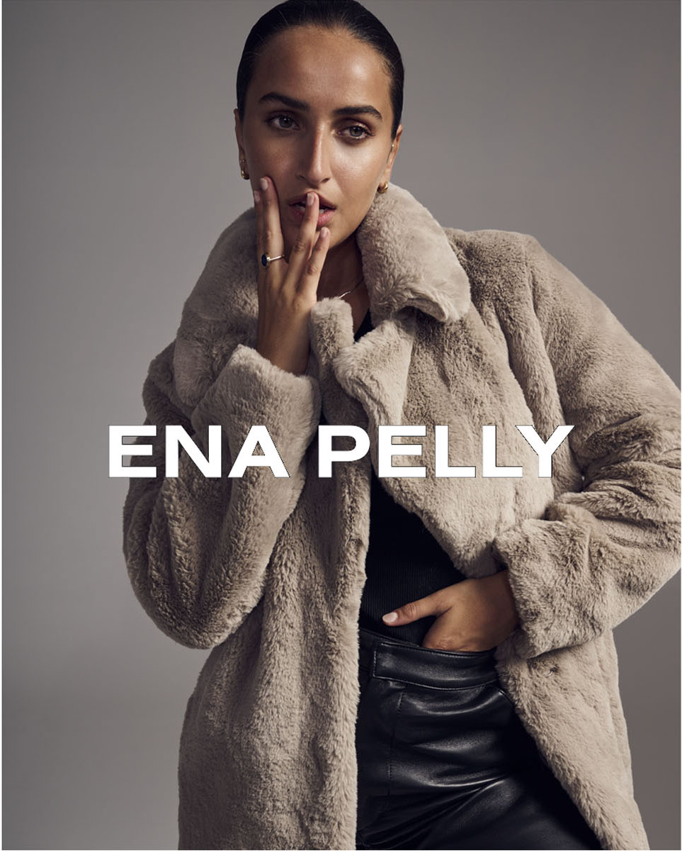 Woman in faux fur coat from Ena Pelly fashion brand, hand near her face, leather pants, studio lighting, beauty shot, neutral background.