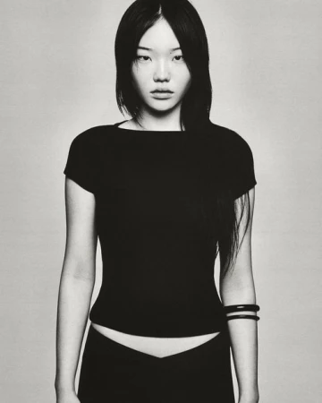 Portrait of a woman wearing a black t-shirt and dark bracelets against a neutral studio background photographed by Joe Brennan
