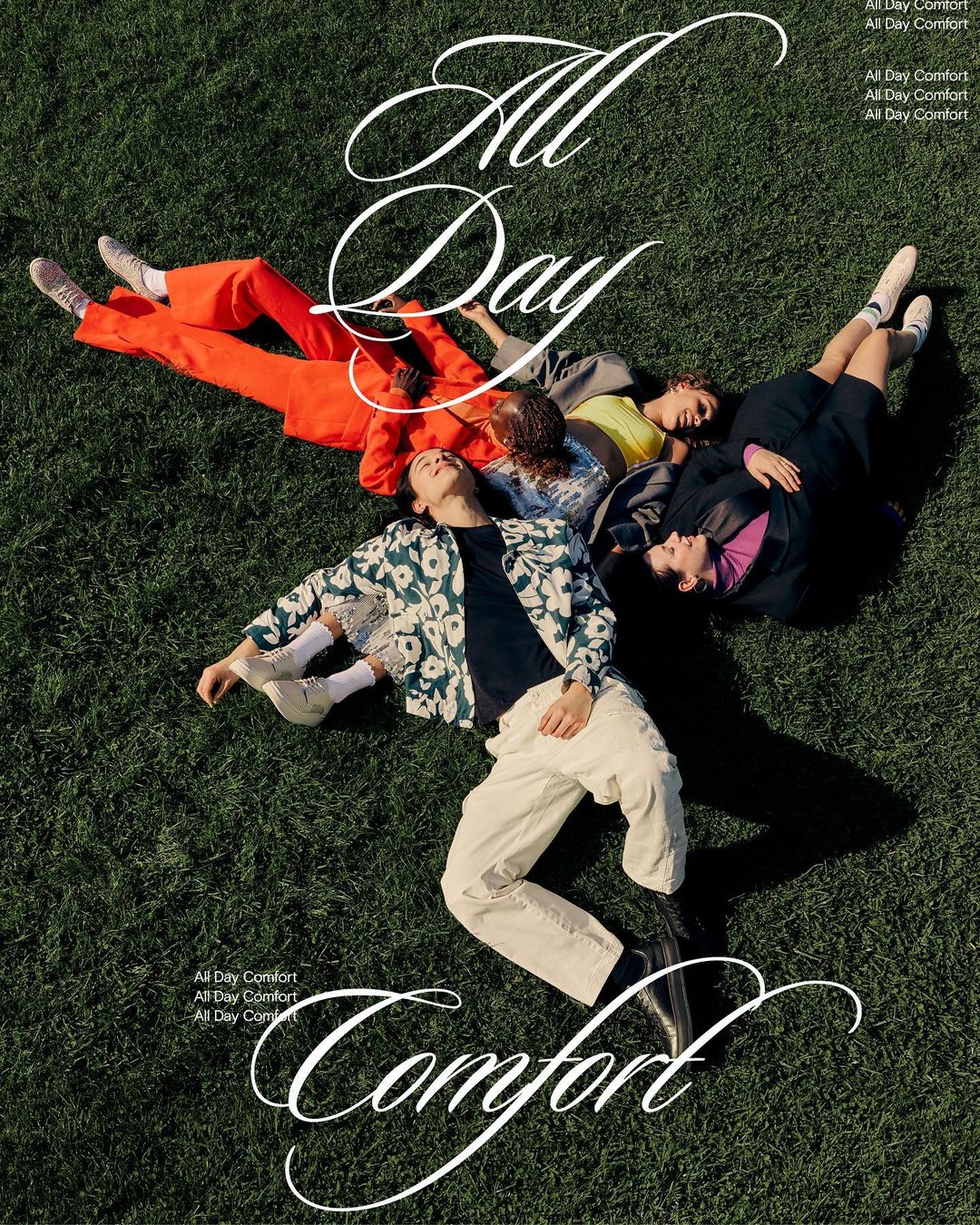 Group of five adults laying on grass in casual fashion apparel, shot from overhead in natural daylight.