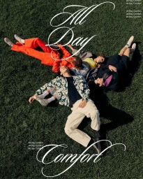 Four people lying in a circle on green grass seen from above, wearing colourful casual clothing and sneakers.