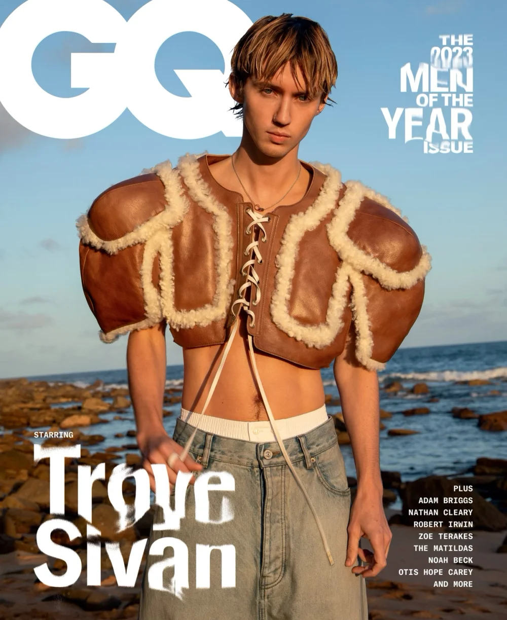 GQ magazine cover featuring a young adult male, Troye Sivan, on a beach with a blue sky in the background and the magazine's masthead.