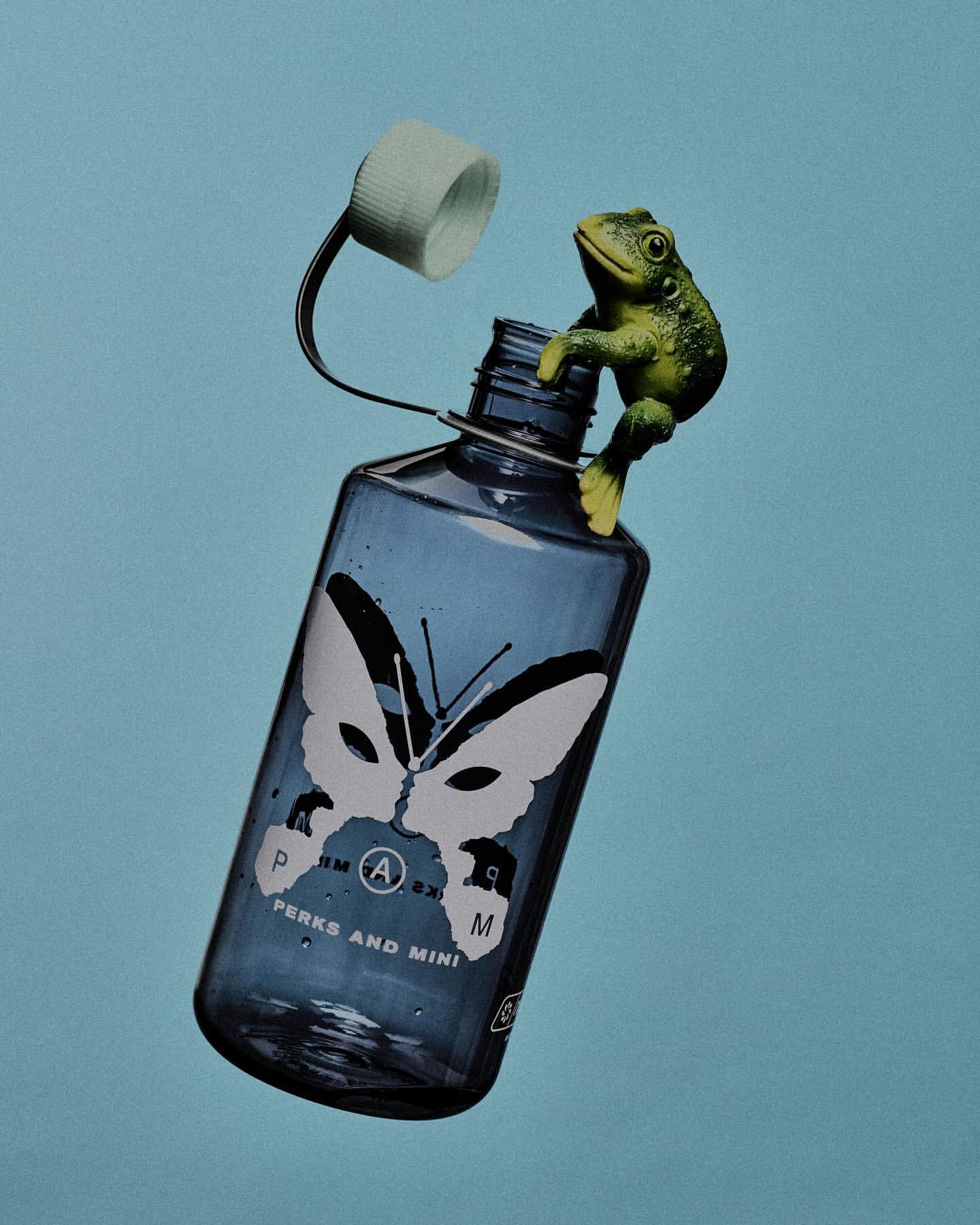Blue water bottle with a white cap and a green toy frog clinging to the neck, set against a solid light blue background.