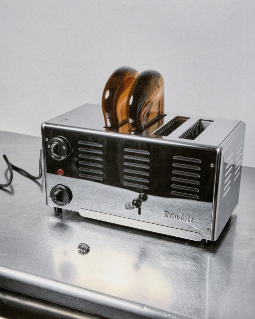Toaster with two slices of toast on a metallic surface, shot in a photo studio with soft lighting. Rowlett brand.
