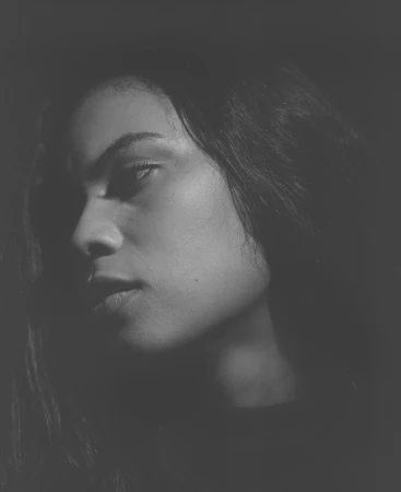 Close-up monochrome portrait of a woman in dramatic low-key lighting by photographer Alain Pottier