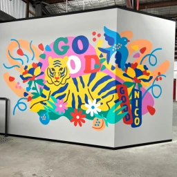 Colorful mural painted on a corner wall featuring a yellow tiger, a blue bird, and flowers by illustrator Nico Nicoson.