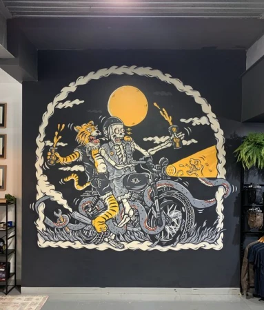 Illustration of a tiger and skeleton riding a motorcycle, stylized with a full moon, comic book effects, and graffiti art elements.