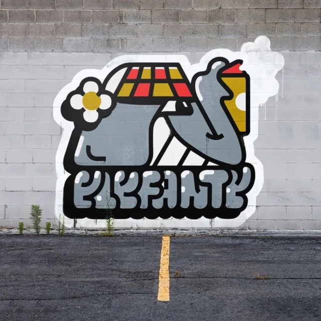Graffiti art on a brick wall featuring a cartoon elephant-like character, floral designs, and the word 'ELEFANTE' in bold letters.