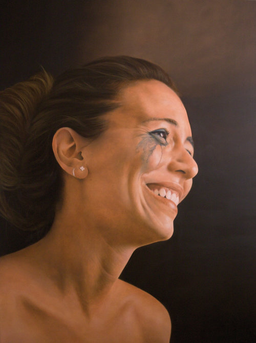 Close-up portrait of a smiling adult woman with smudged makeup, set against a dark background, showcasing a raw, emotive aesthetic.