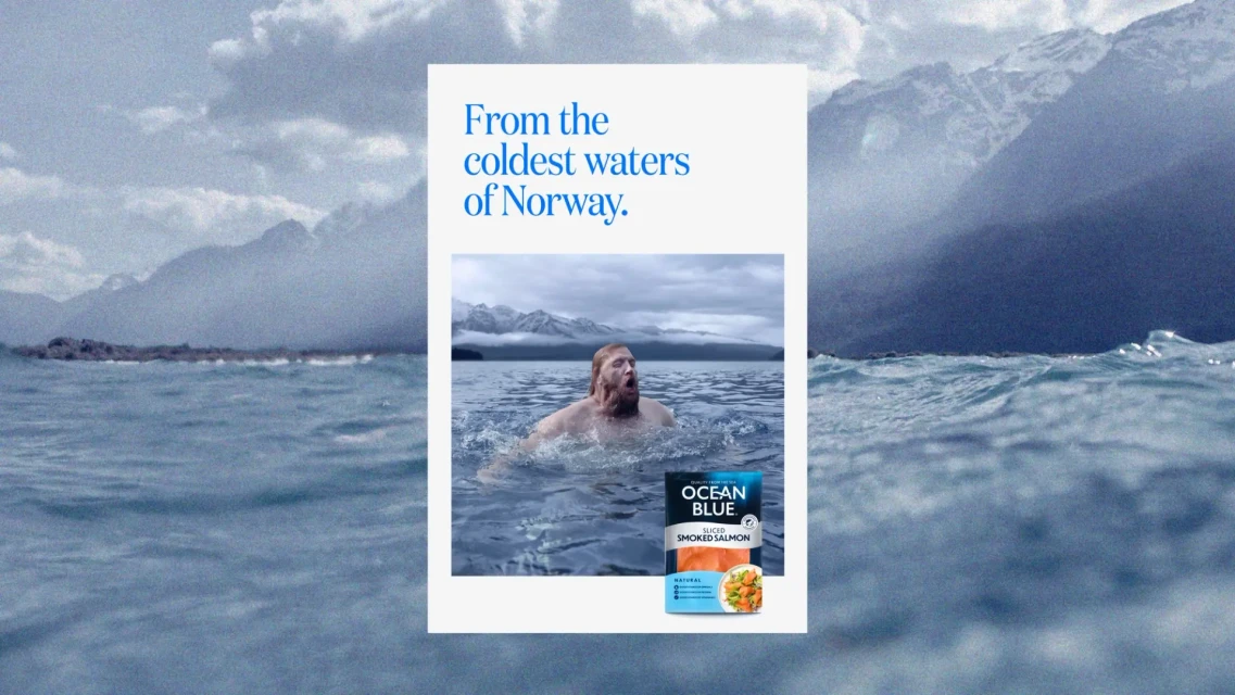 An advertisement features a man in ocean water next to the Ocean Blue sliced smoked salmon package, promoting its origin from Norway.