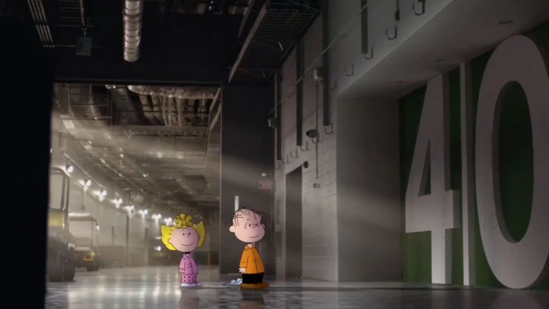 Cartoon characters Charlie Brown and Sally stand in an industrial-looking space with concrete floors and large number 40 on the wall.