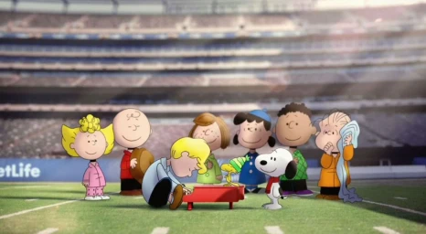 Illustrated group of Peanuts characters gathered around a small red piano on a football field in a stadium