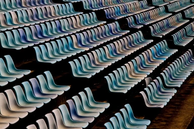 An elevated perspective of rows of empty blue and white stadium seats in Sydney captured by Australia Film Locations.