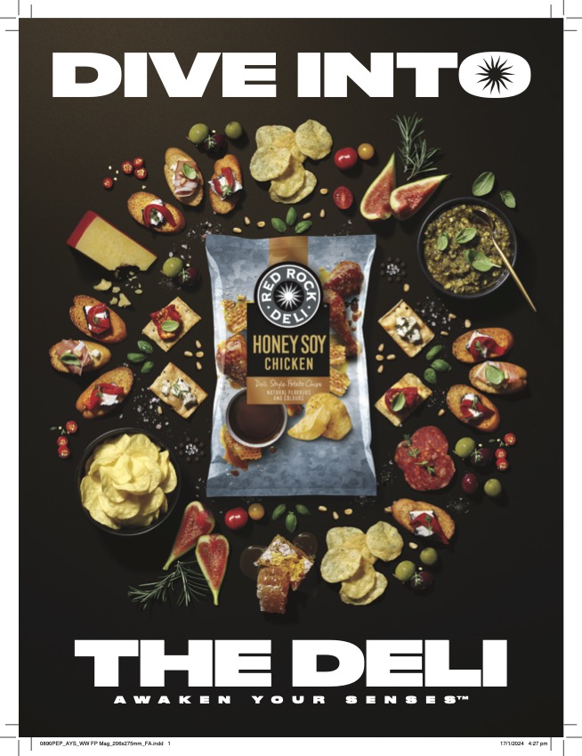 Overhead food photography of Red Rock Deli Honey Soy Chicken chips surrounded by appetizers like crostini, olives, and figs on black background.