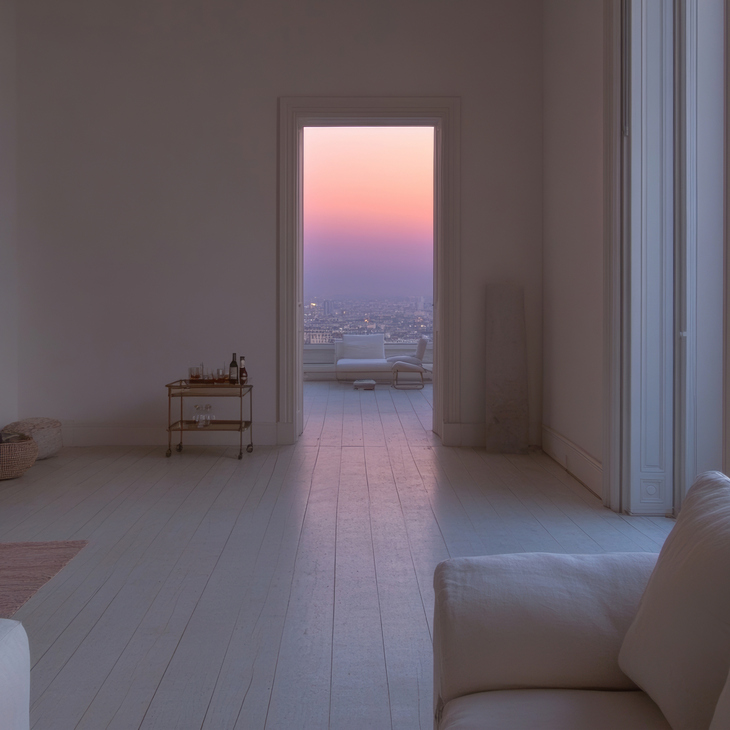 Open doorway leads from an all-white room to a balcony with a cityscape view under a pastel pink and purple sky at dusk.