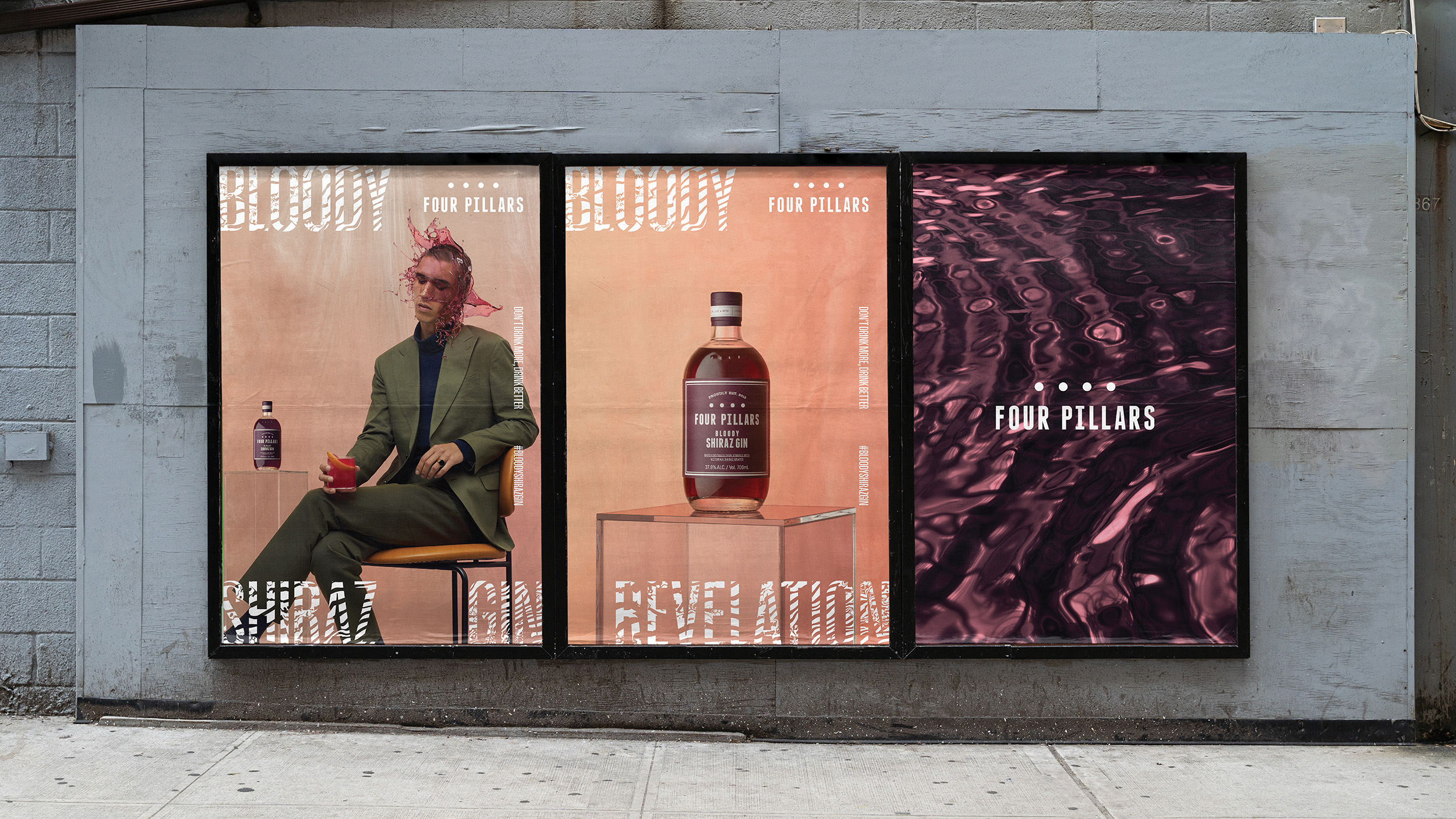 Outdoor billboard advertisement features a man, liquor bottle, and abstract water pattern for Four Pillars Bloody Shiraz Gin.