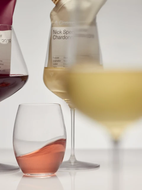 Studio shot of wine glasses with red, white, and rose wine, set against a white background, highlighting the colors and shapes.