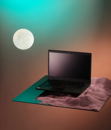 Laptop on textured surface with creative lighting, featuring turquoise and amber hues, against a backdrop with a spherical light.