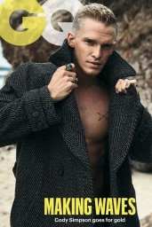 Cody Simpson wearing a dark herringbone coat outdoors against a rocky beach background for a magazine cover.