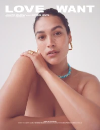 Model Jennifer Atilemile posing with gold hoop earrings and a blue beaded necklace against a plain white background