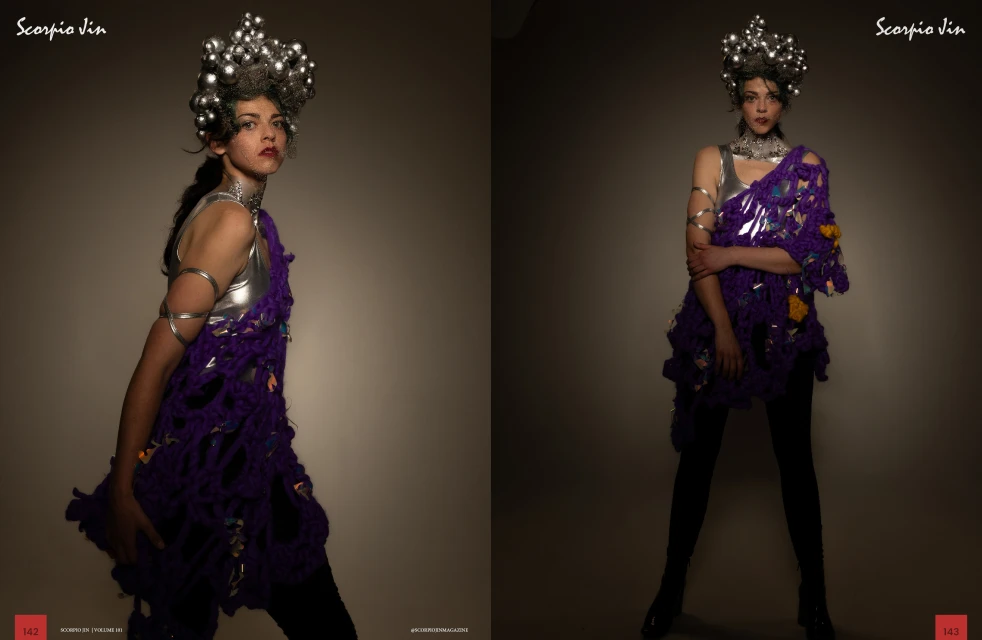 Woman in a silver top, headpiece, and purple crochet dress posing in front of a neutral background in a studio environment. 