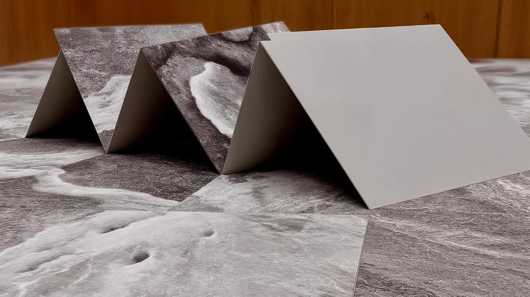 Geometric paper sculpture featuring black and white ocean wave patterns; minimalist design aesthetic with subtle depth of field.
