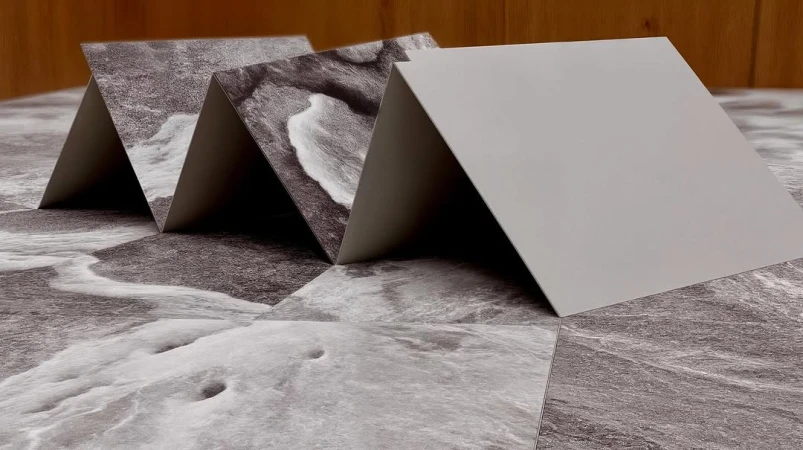 Geometric paper sculpture featuring black and white ocean wave patterns; minimalist design aesthetic with subtle depth of field.