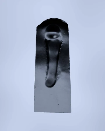Abstract photograph of a solid, black, rectangular sculpture with an arched top against a plain, light grey background.