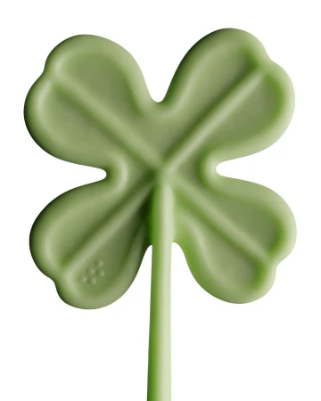 Close-up of a green four-leaf clover lollipop on a white background, symbolizing luck and St. Patrick's Day.