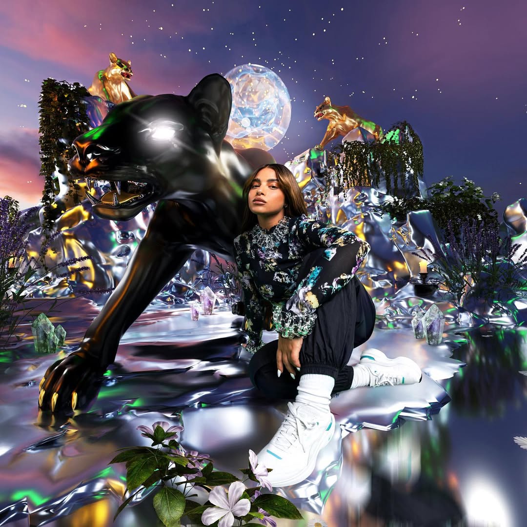 Woman poses next to a dark, metallic jaguar statue under an artificial moon and starscape, surrounded by reflective rock formations.