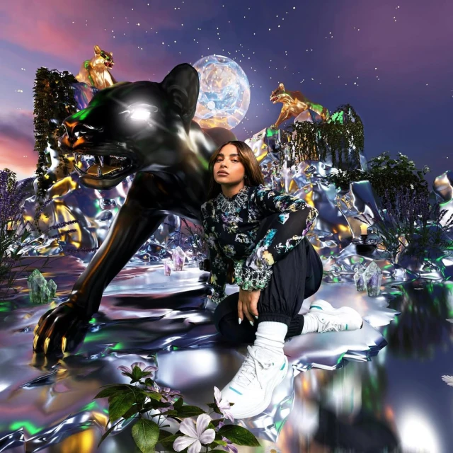 Woman poses next to a dark, metallic jaguar statue under an artificial moon and starscape, surrounded by reflective rock formations.