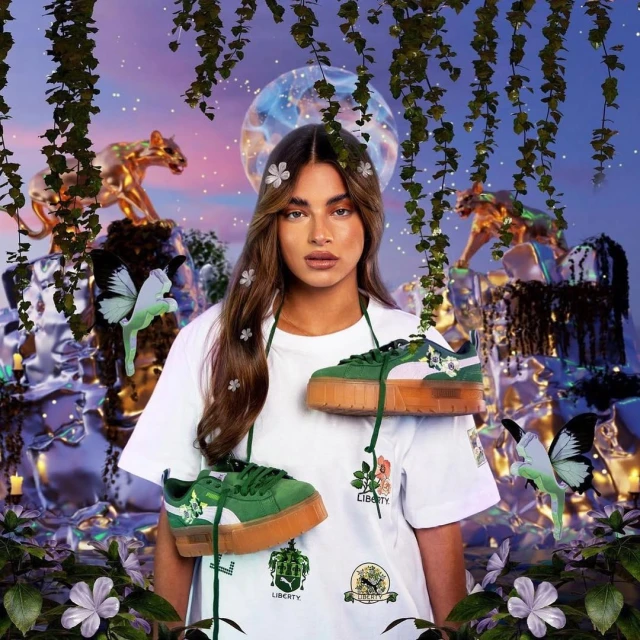Brunette model with tan skin posing with green and white Puma sneakers hanging around her neck, adorned with floral elements.
